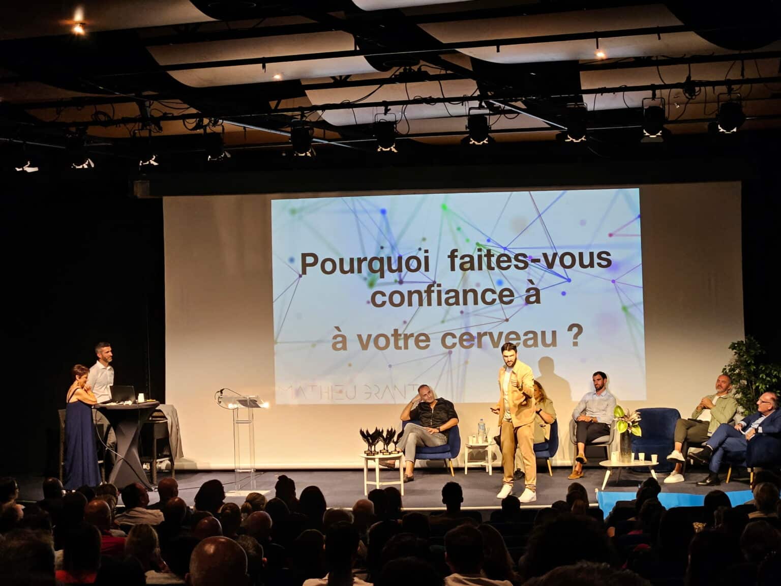 Mathieu Grant en conférence biais cognitifs devant une grande salle d'entreprise